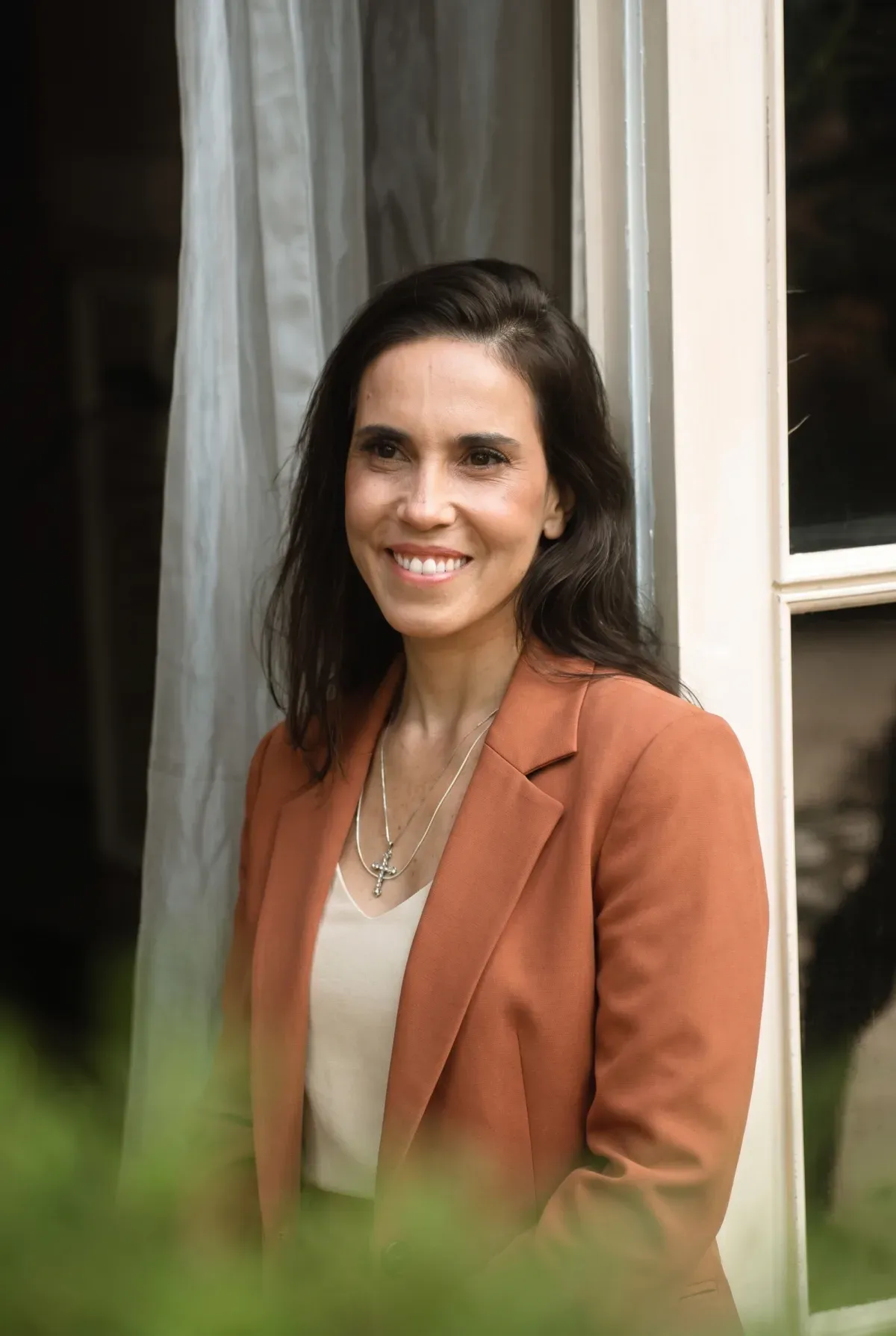 Erica Duque, nutricionista, ao lado da janela em luz natural