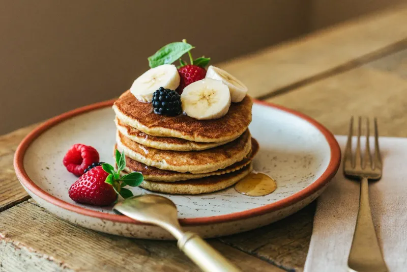 Pilha de panquecas douradas de banana e aveia com rodelas de banana por cima