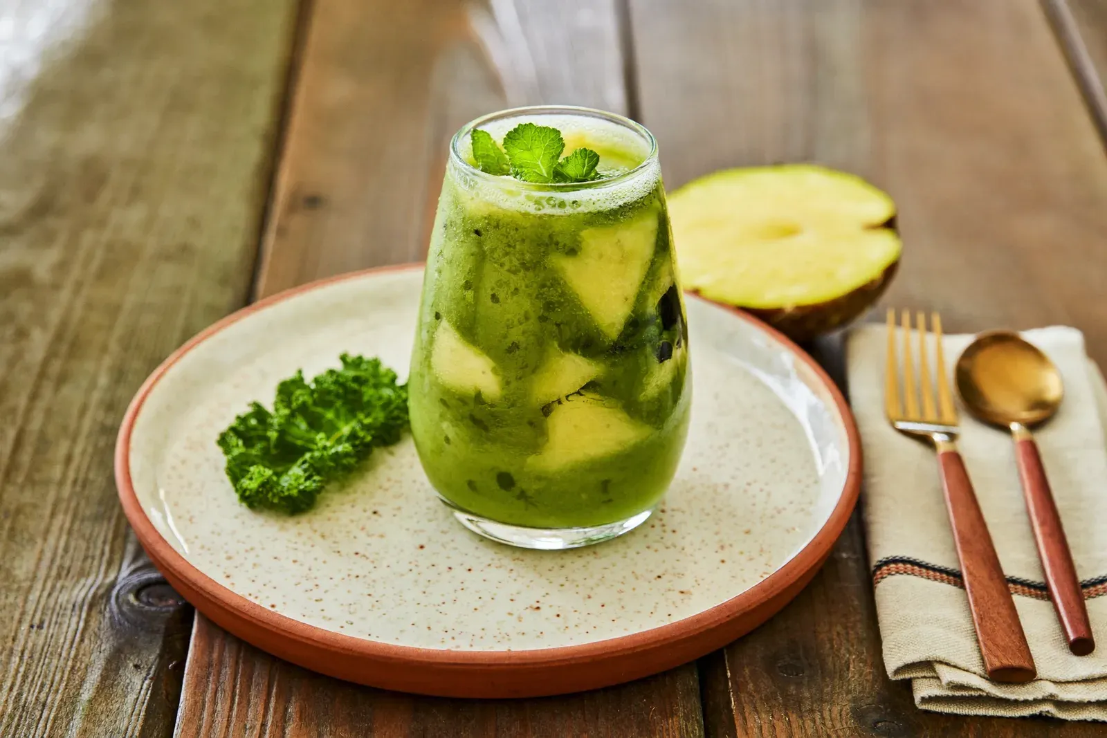 Copo alto com smoothie verde e folhas de hortelã